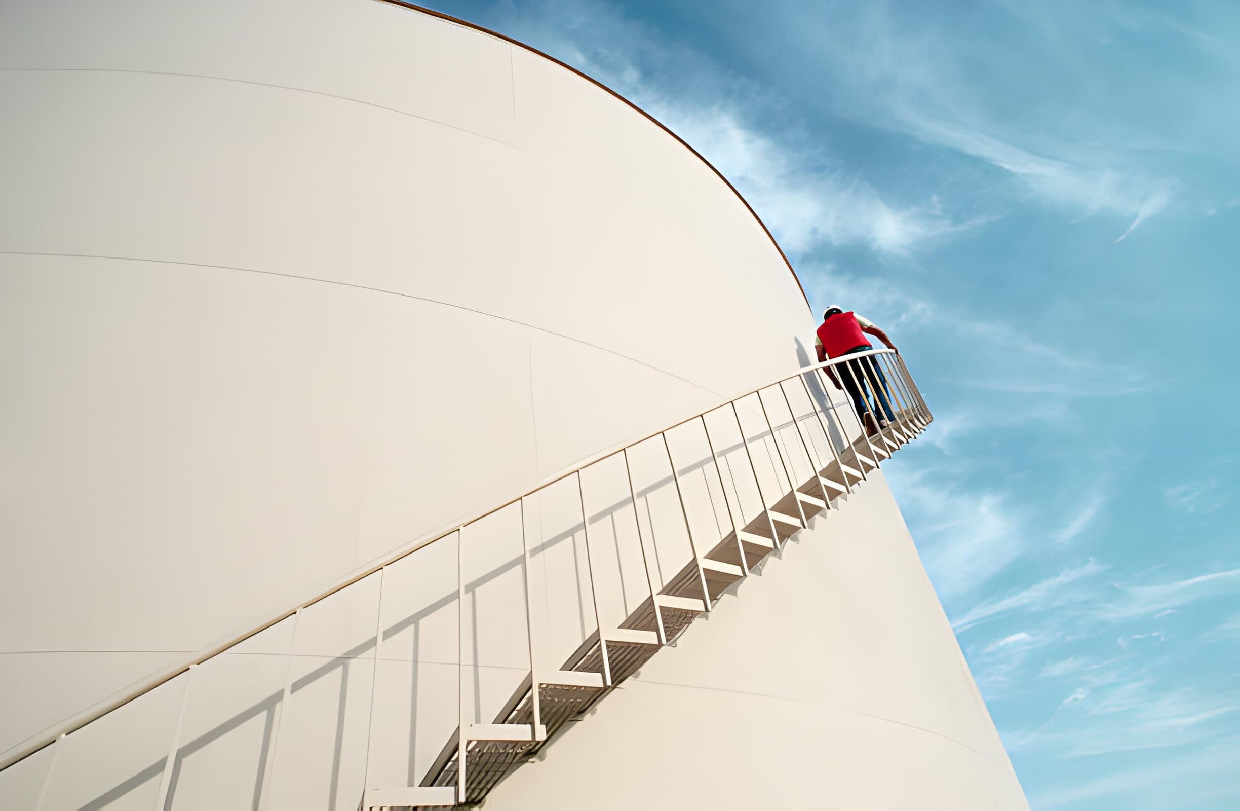 A worker climbing the stairs of a tank